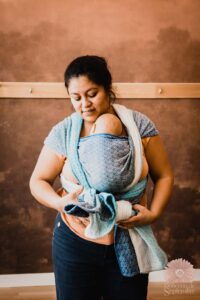 Stéphanie, formatrice en portage bébé, portant un nourrisson et accompagnant les professionnels dans l’apprentissage et l’intégration du portage dans leur métier.