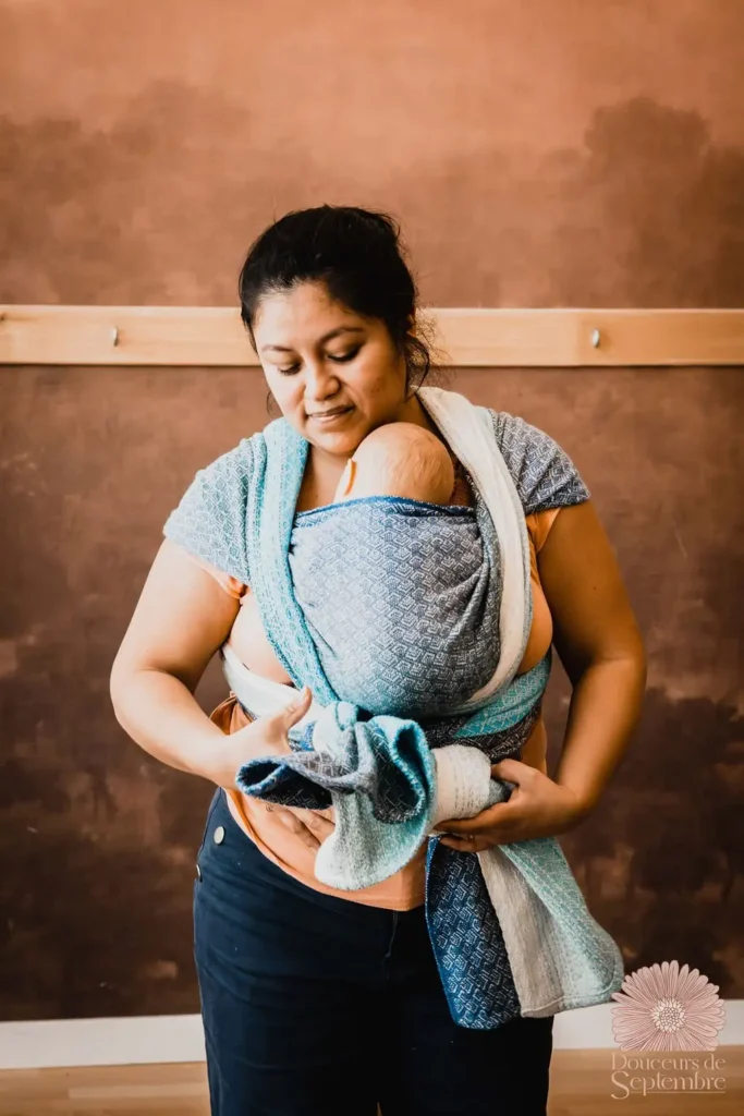 Stéphanie, formatrice en portage bébé, portant un nourrisson et accompagnant les professionnels dans l’apprentissage et l’intégration du portage dans leur métier.