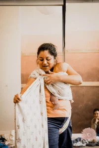 Stéphanie, formatrice en portage bébé, portant un nourrisson et accompagnant les professionnels dans l’apprentissage et l’intégration du portage dans leur métier.